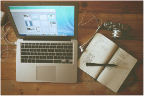 Laptop, notebook, and pen on tabletop